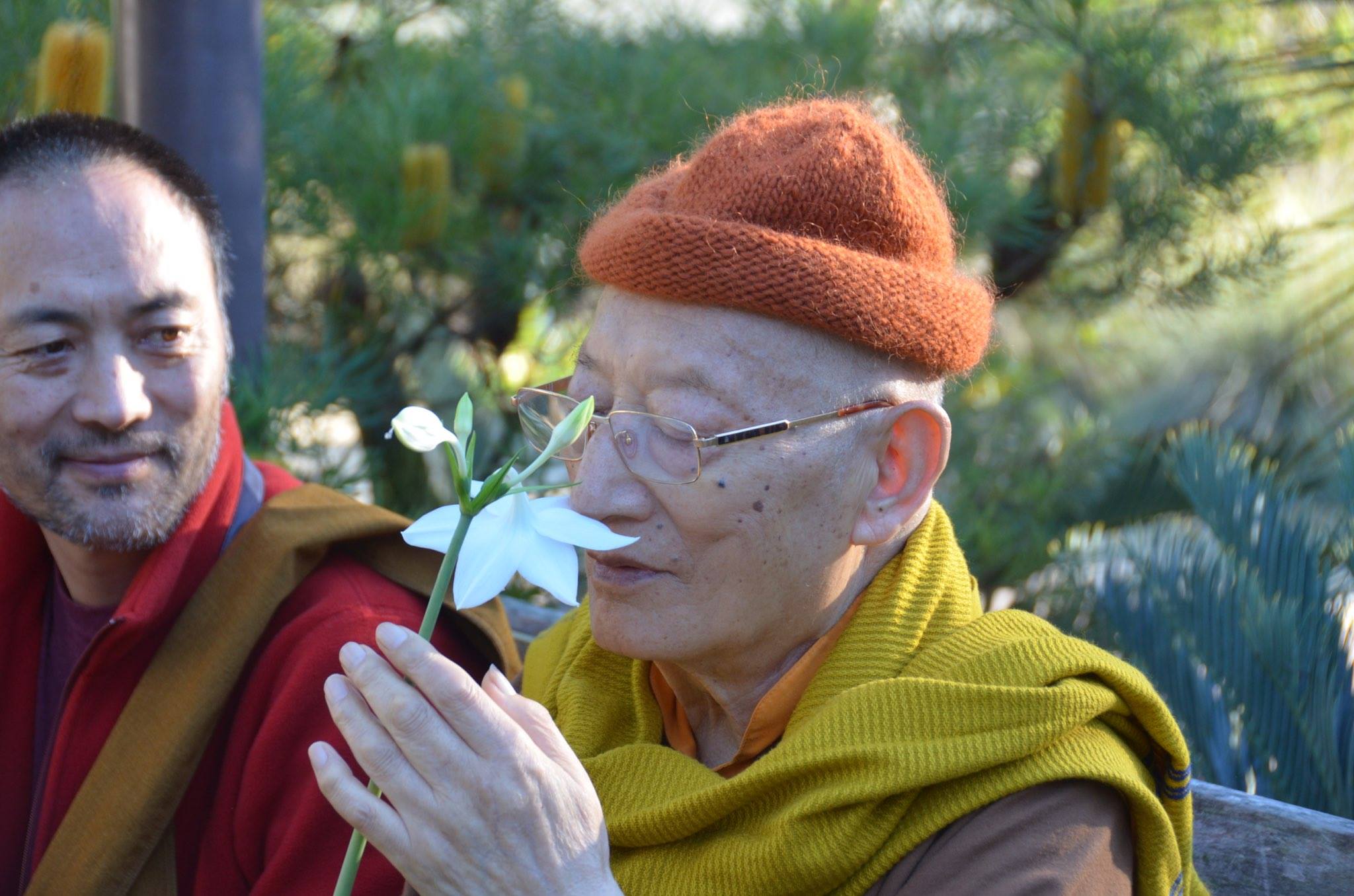 Khenche Rinpoche smelling a flower
